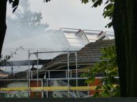 Beschädigtes Dach, Rauchschwaden über der Brandstelle