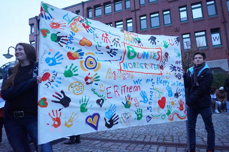 Transparent mit bunten Handabdrücken, Schriftzug: Buntes Norderstedt