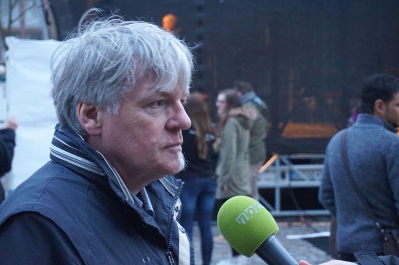 Wolfgang Blankschein von der Seite vor einem grünen Mikrofon von noa4